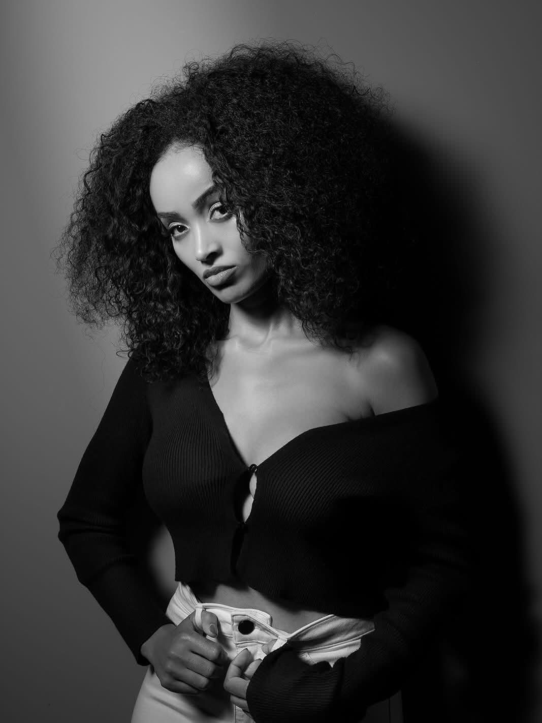 Black-and-white editorial portrait of Mimi in an off-shoulder knit