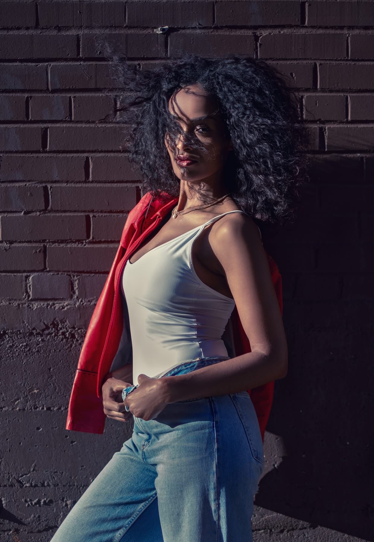 Model Mimi in a flowing burgundy silk dress at golden hour
