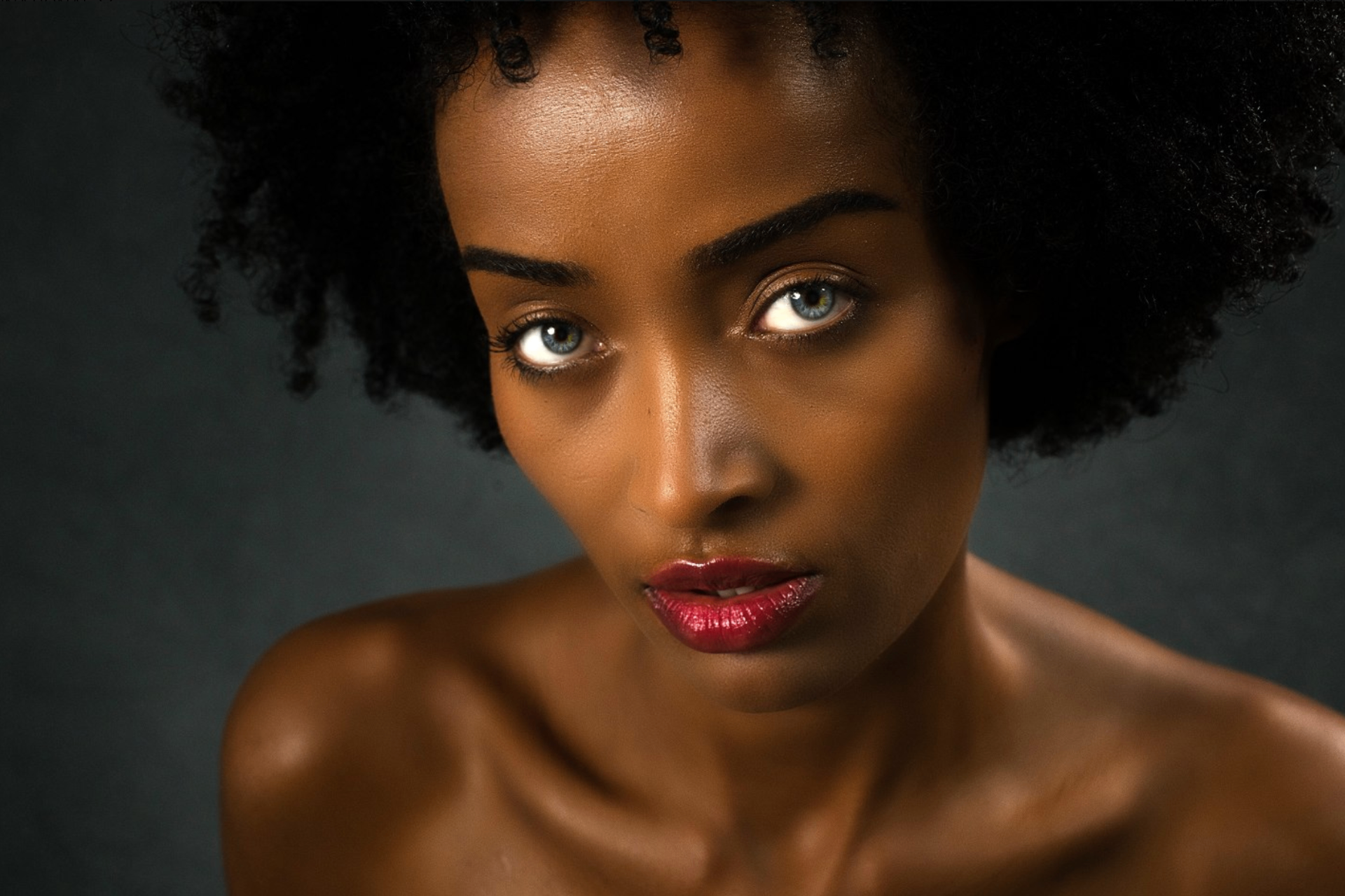 Beauty close-up of Mimi with deep red lip and dewy skin