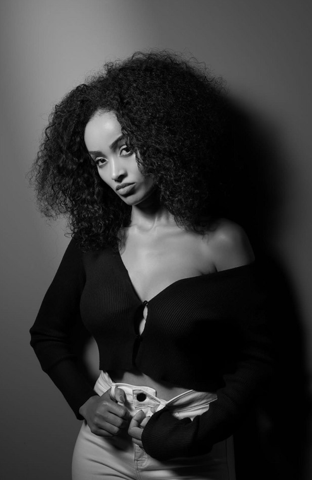Black-and-white off-shoulder portrait of Mimi with sculpted shadow