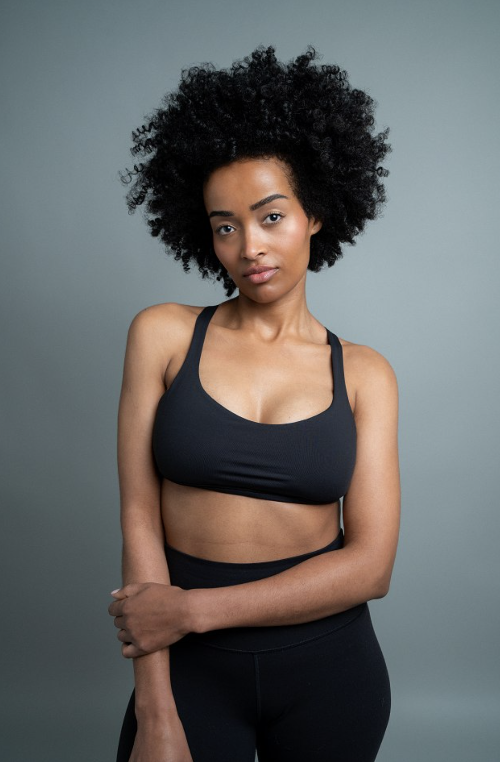 Mimi in black activewear, studio portrait for a movement and wellness campaign